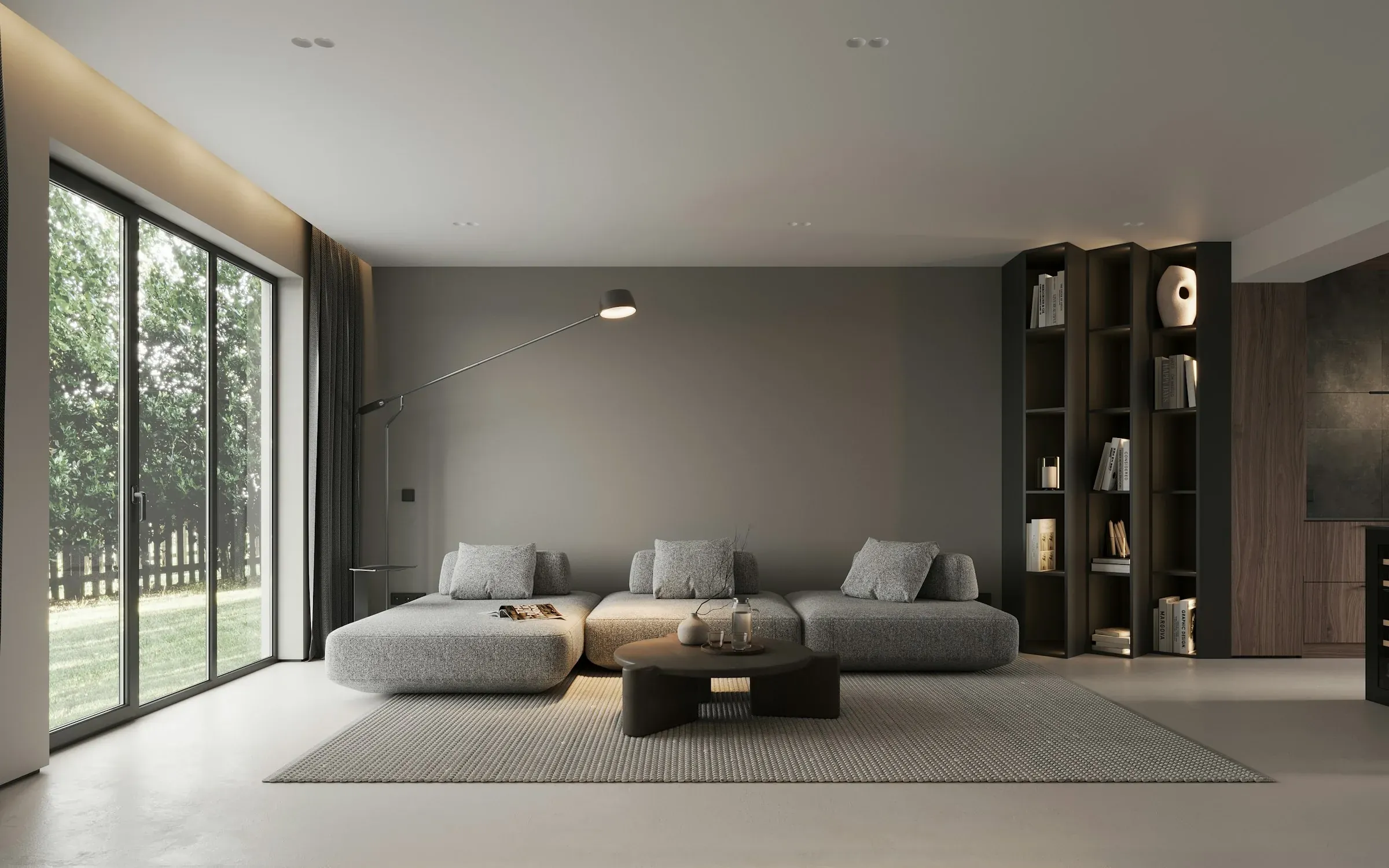 A calm living room with a grey sofa, a dark feature wall, tall shelves and glass doors to the garden